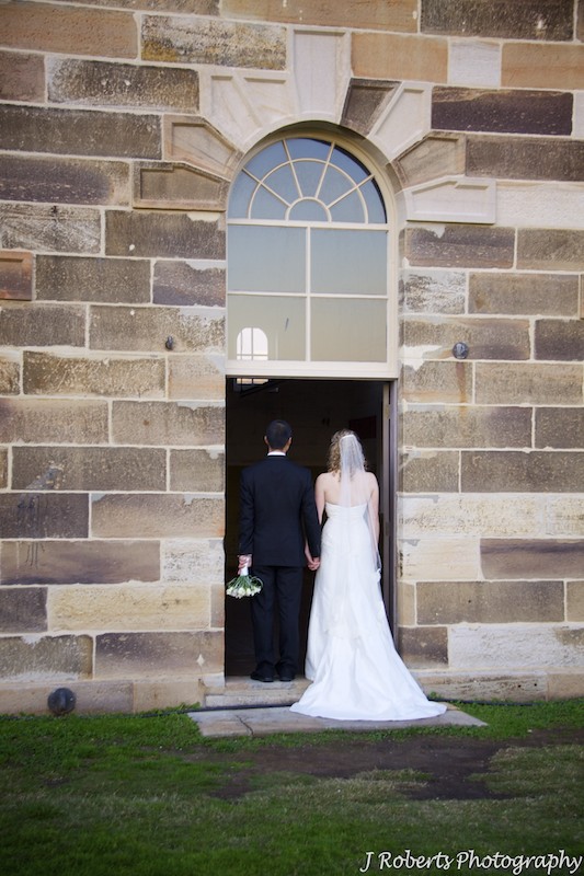 Bridal couple walking through a doorway - wedding photography sydney